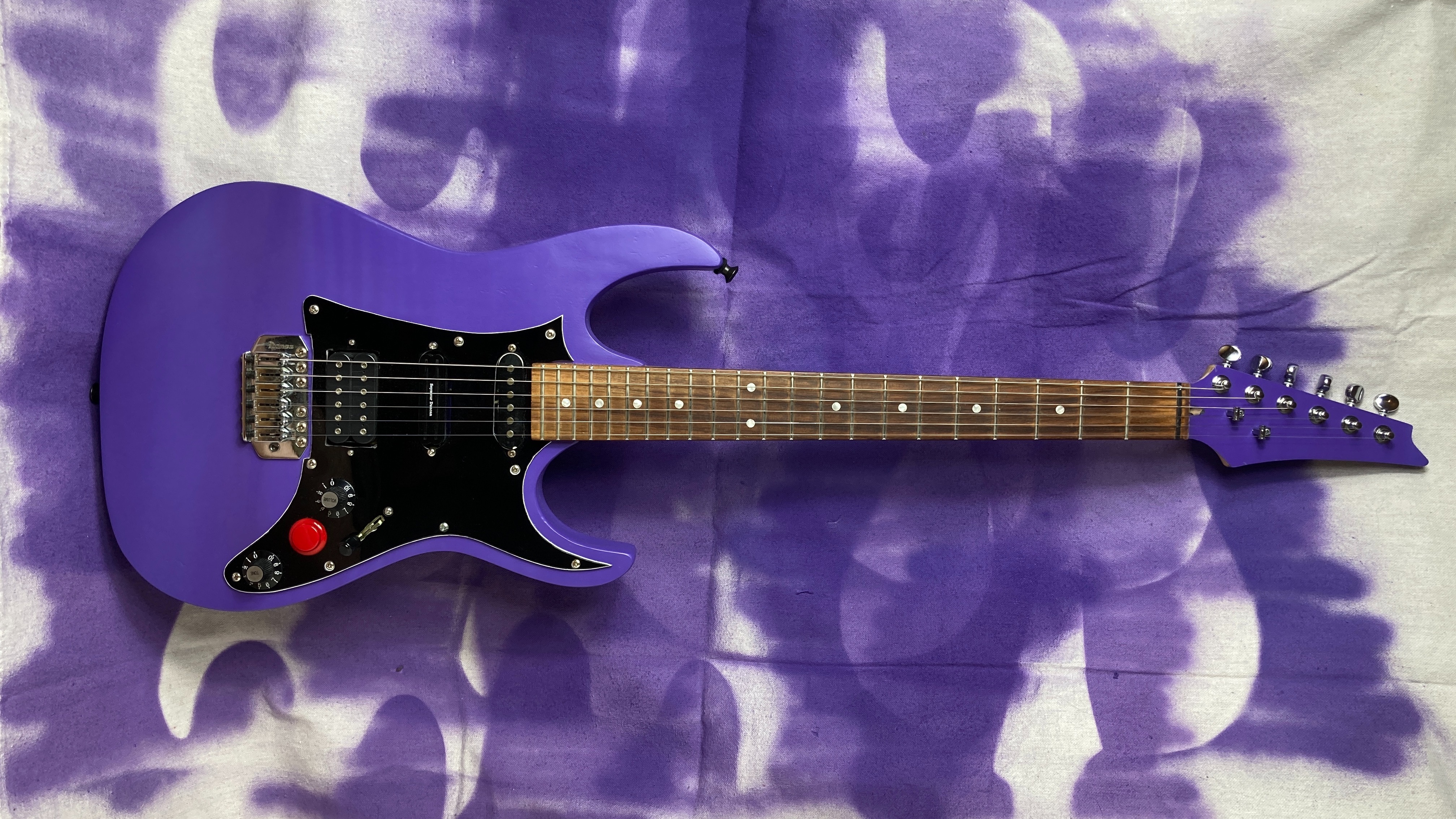My newly painted purple guitar resting on the canvas cloth I painted it on. It shows a few outlines of my guitar and looks cool.